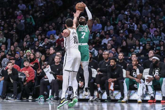 Boston Celtics guard Jaylen Brown (7) takes a three-point shot over Brooklyn Nets guard Ben Simmons (10)